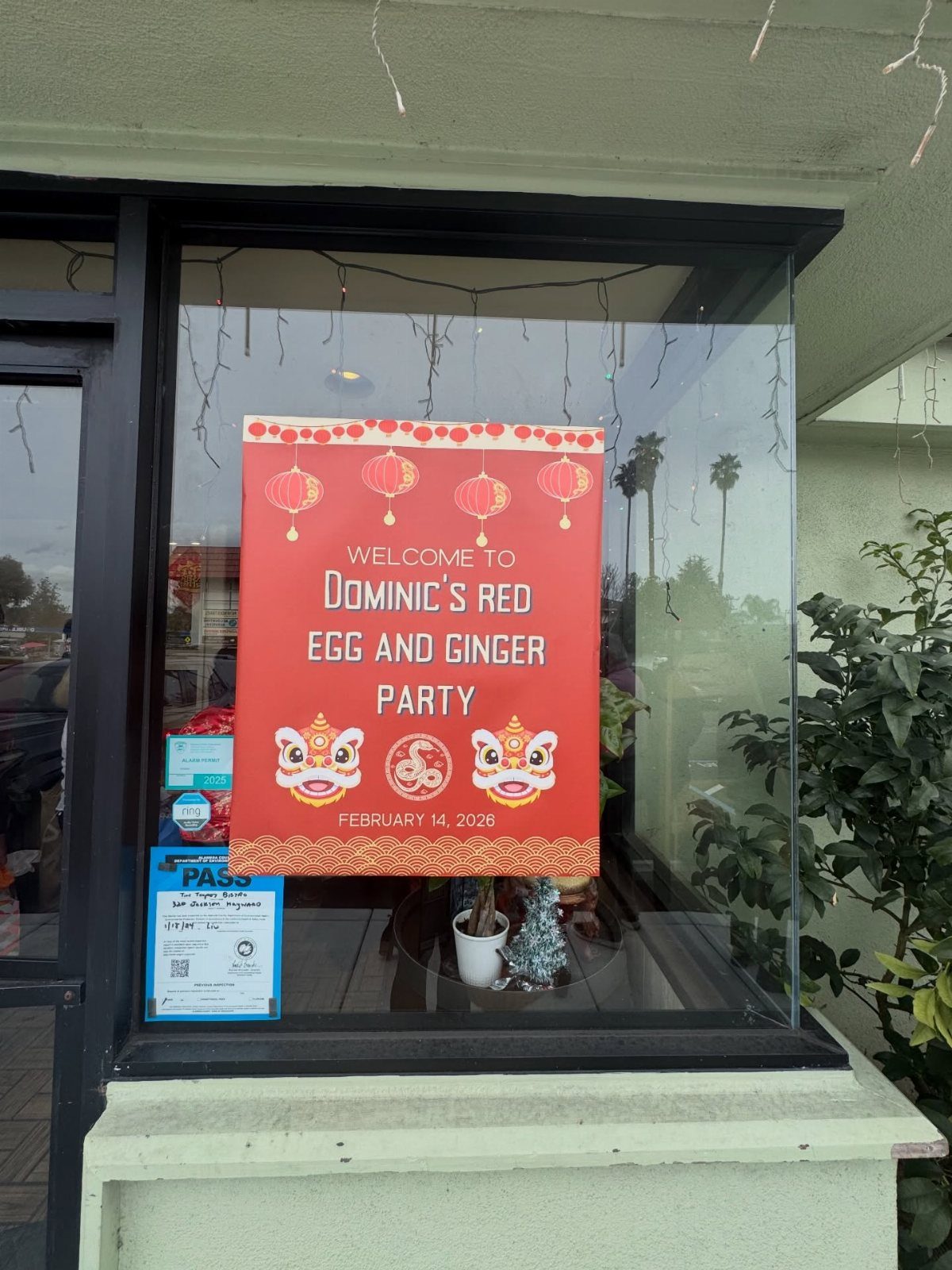 Red welcome sign for a Red Egg and Ginger Party on a window