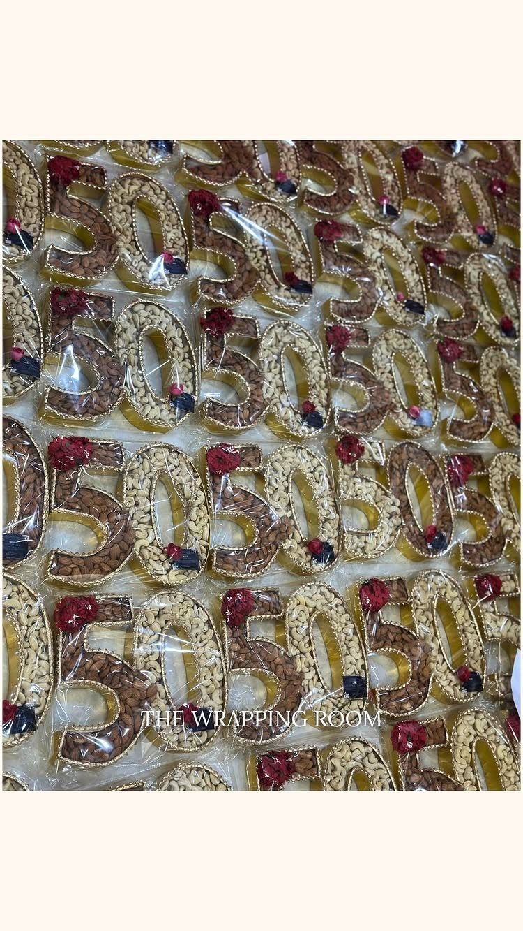 Gold number 50 decorations with small flowers wrapped in clear plastic packaging.