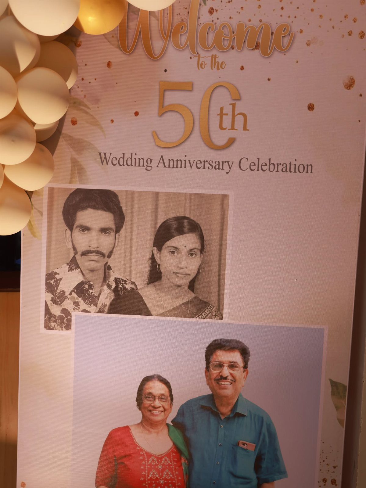 Welcome sign for 50th anniversary with gold text and couple's photos