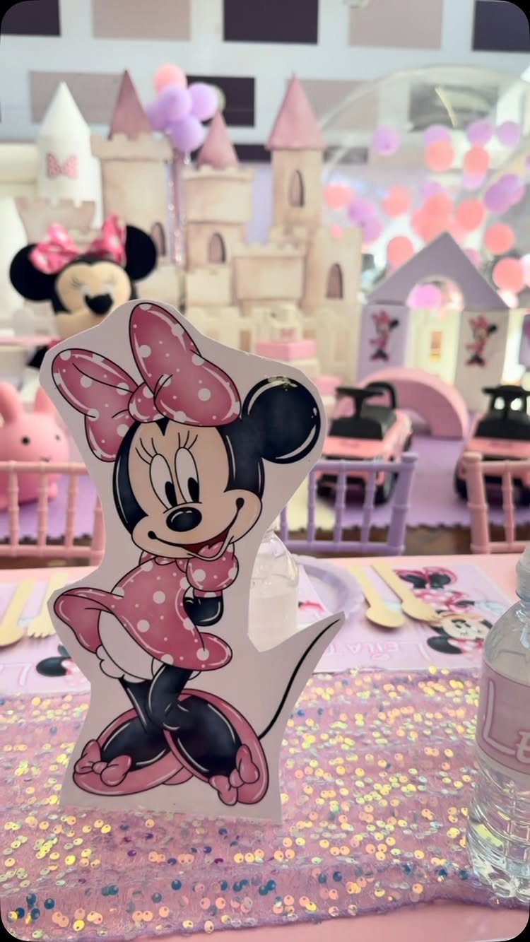 Minnie Mouse cutout on a pink sequined table with a toy castle background