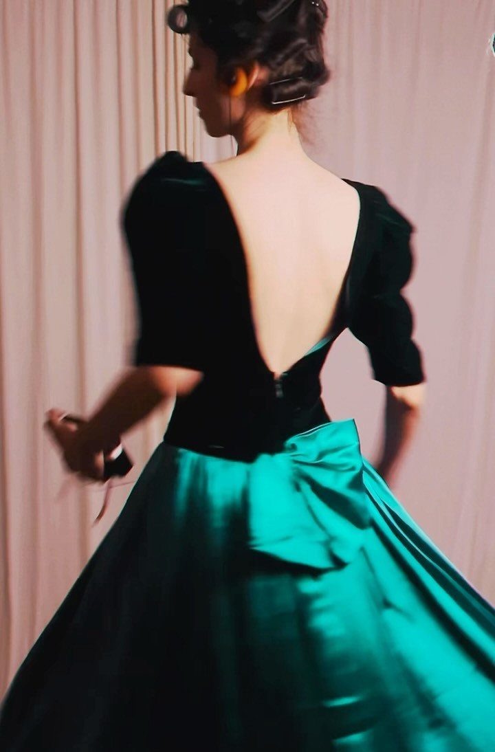 Woman in a black velvet and emerald green satin vintage prom dress