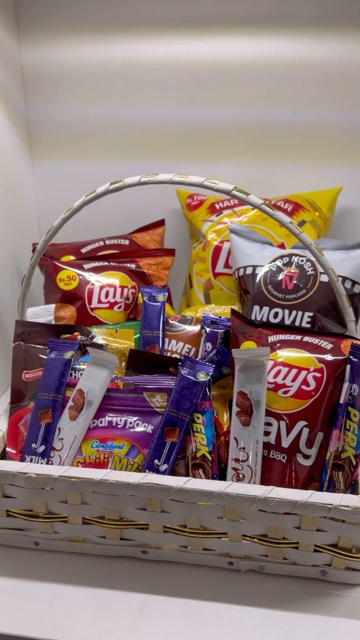 White woven gift basket filled with assorted potato chips and chocolate candies.