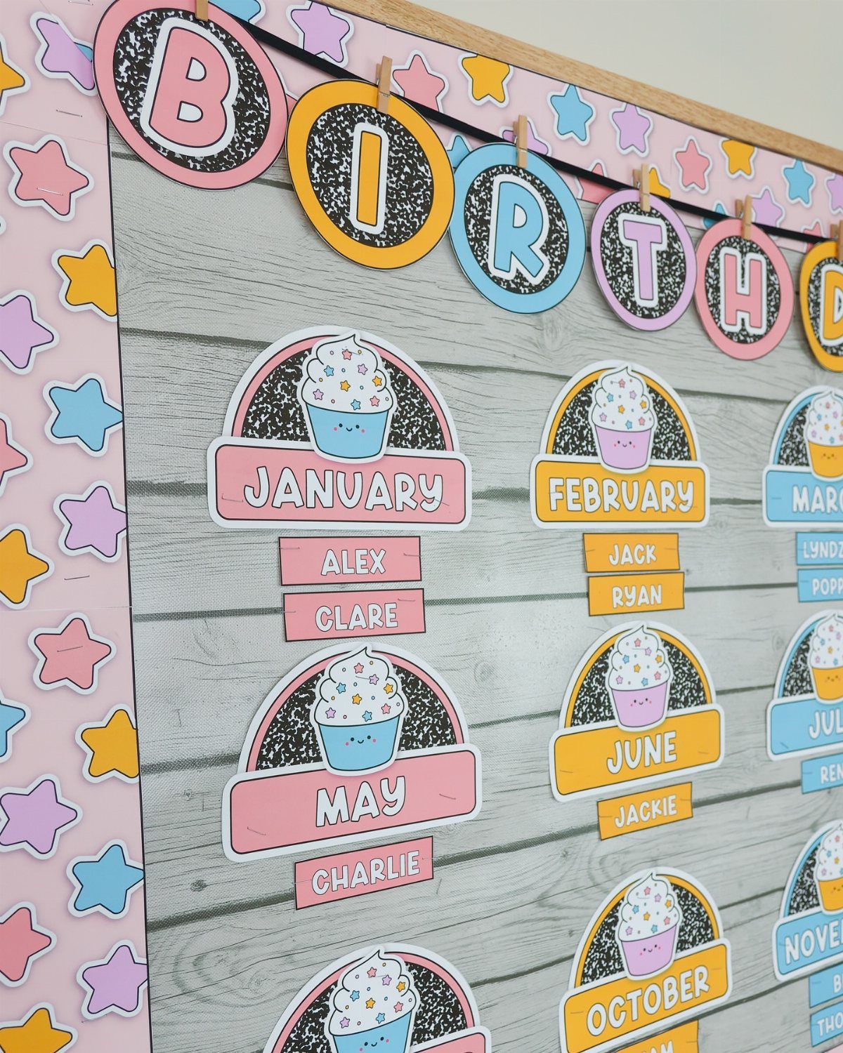 Classroom birthday board with colorful letters, cupcake icons, and student names by month.