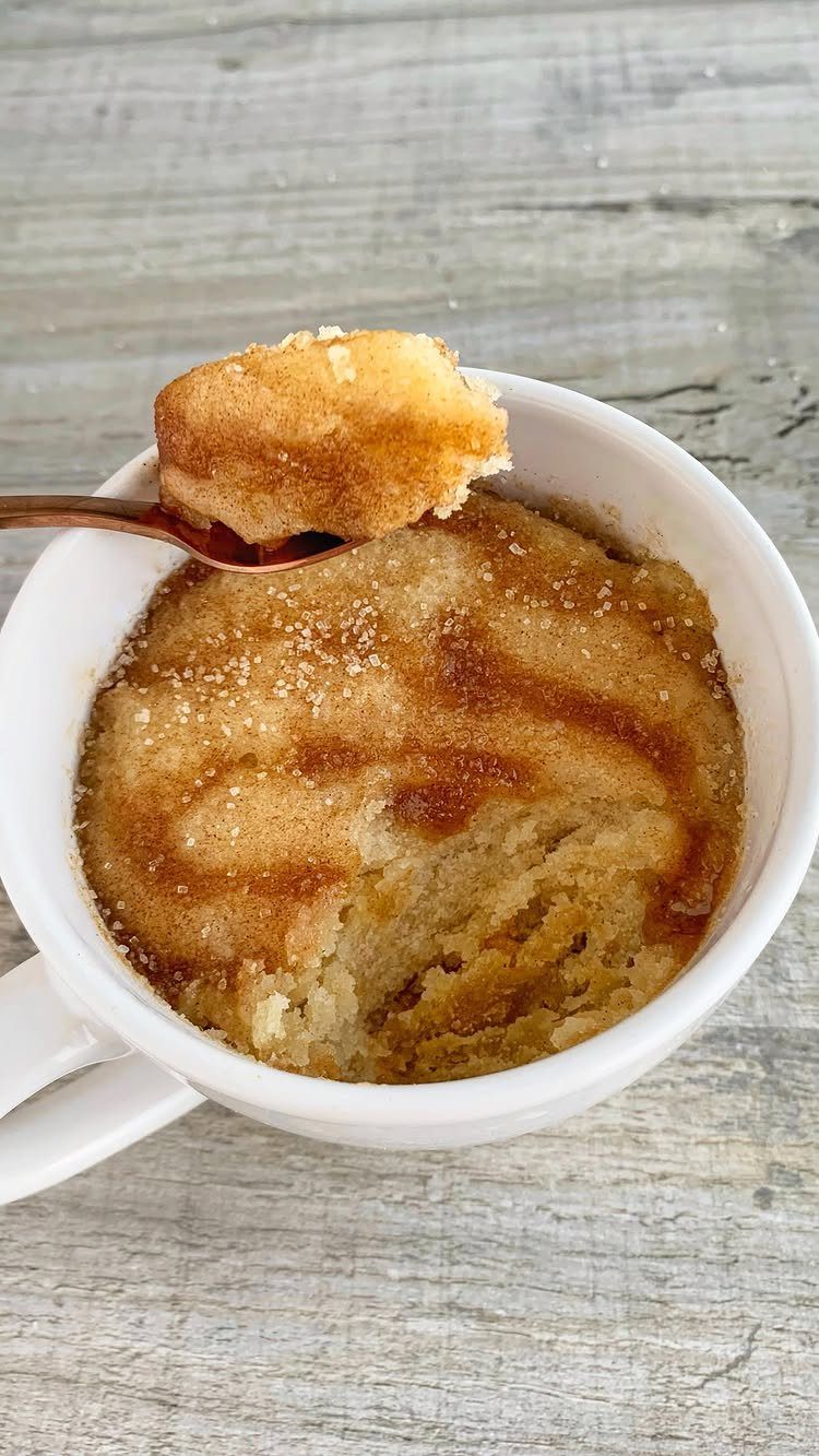 Coffee cake mug cake with cinnamon swirl topping in a white ceramic mug.