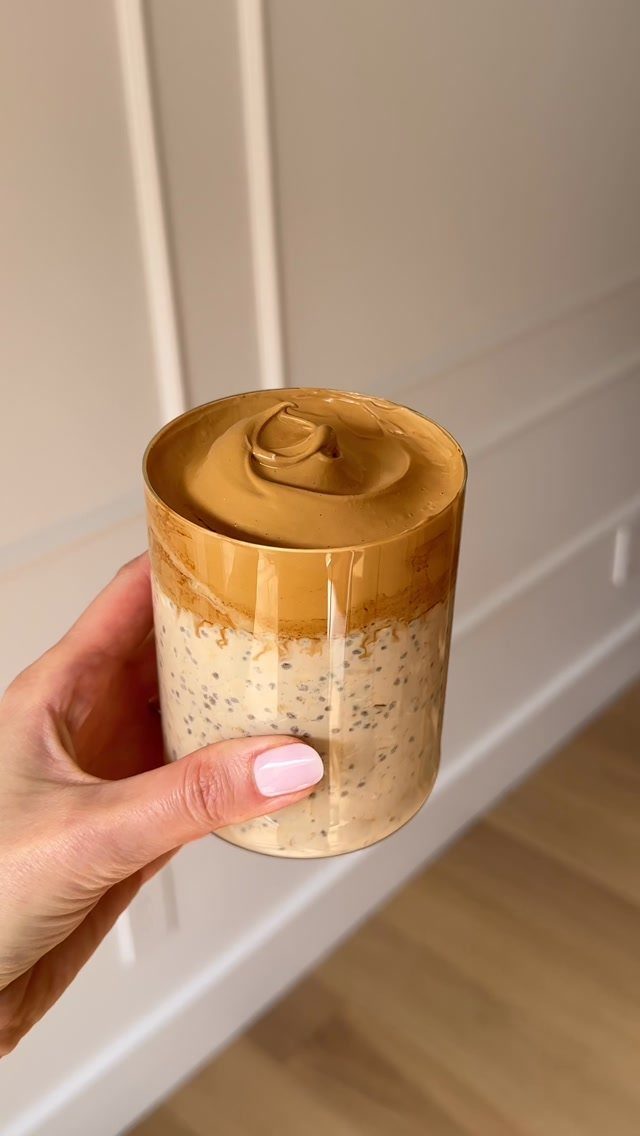 Creamy overnight oats with chia seeds topped with whipped coffee foam in glass.