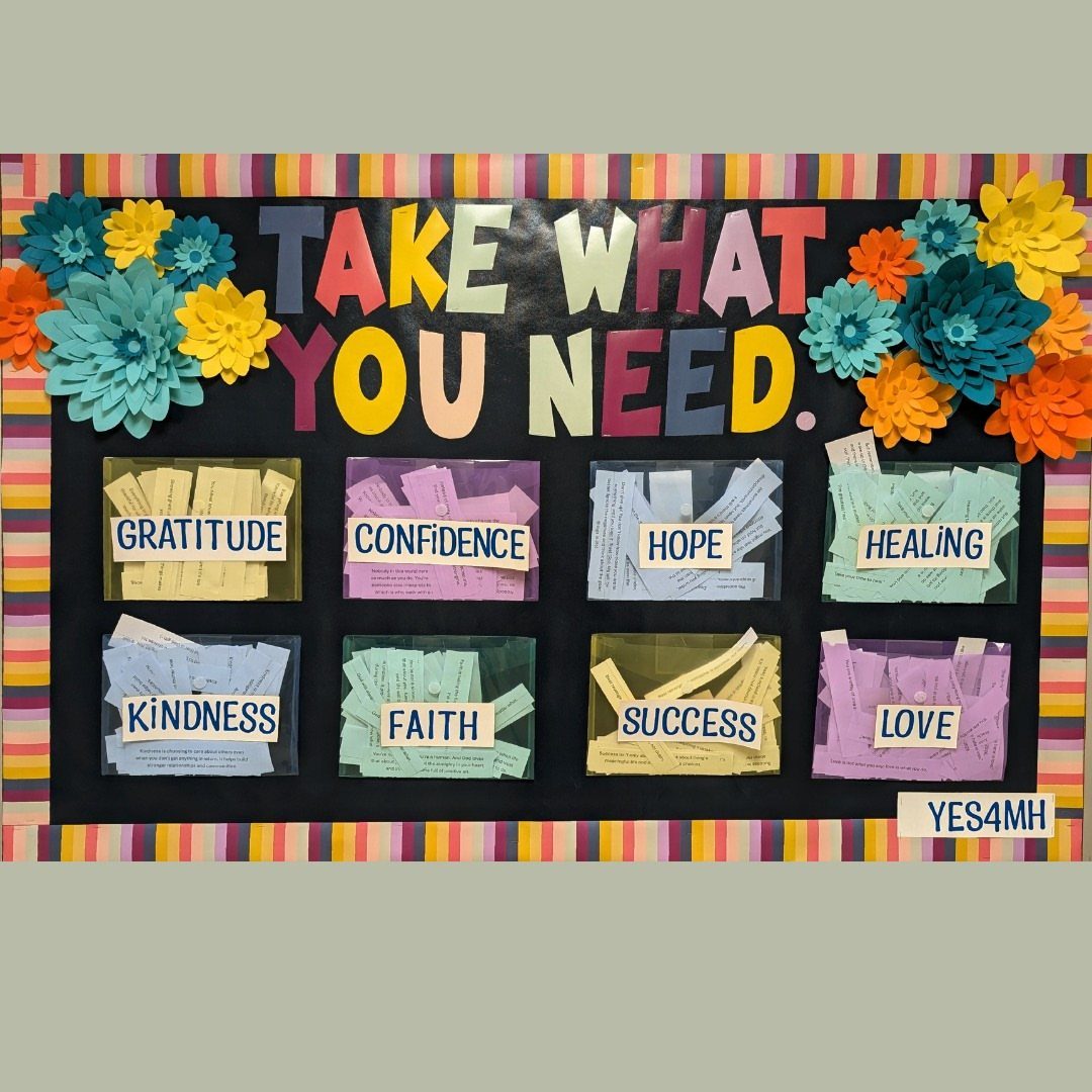 Bulletin board with 'Take What You Need' text and pockets of positive affirmations.