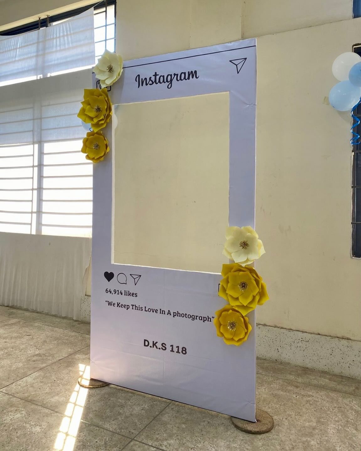 Instagram post frame cutout decorated with yellow flowers standing in a room