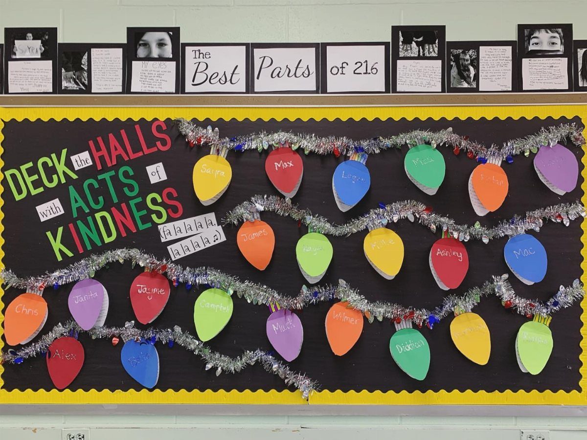 Kindness bulletin board with colorful paper light bulbs and silver tinsel garlands.