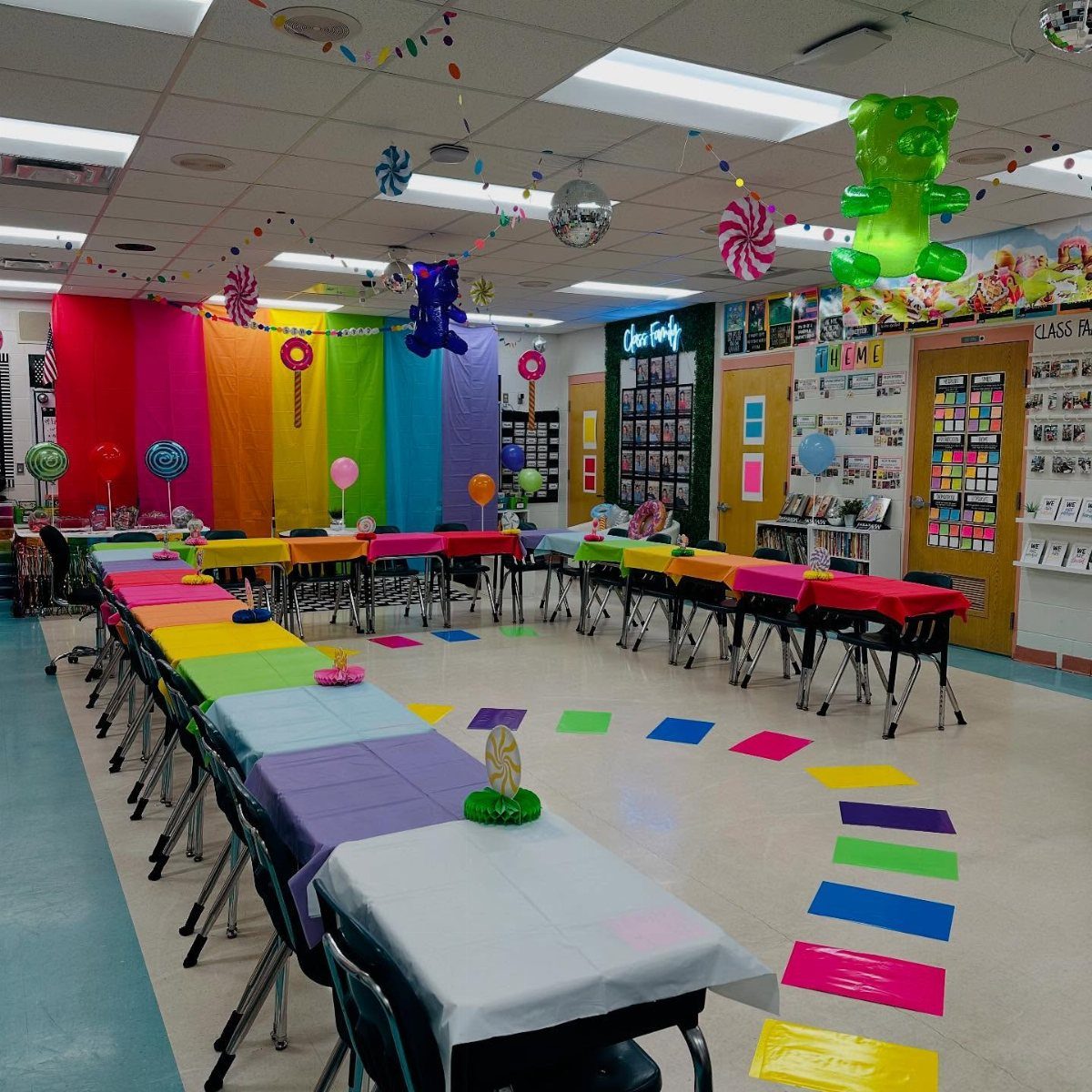 Rainbow decorated classroom with candy swirl ornaments and a large gummy bear balloon.