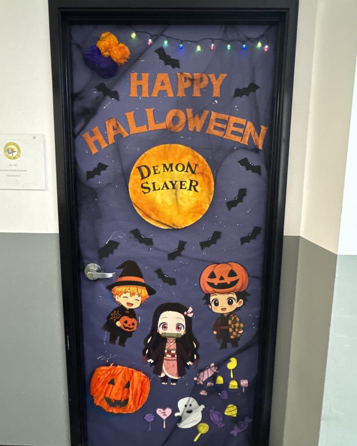 Halloween decorated classroom door with purple background, cartoon characters, and orange lettering.