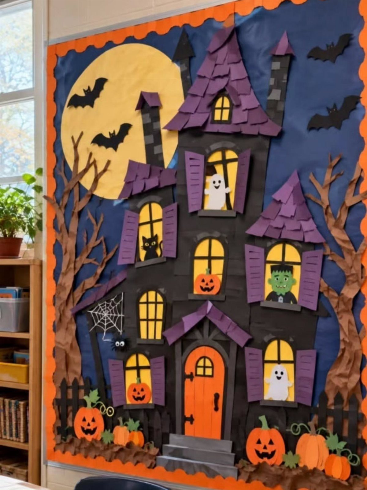 Haunted house classroom door decoration with purple roof, orange door, and yellow moon.