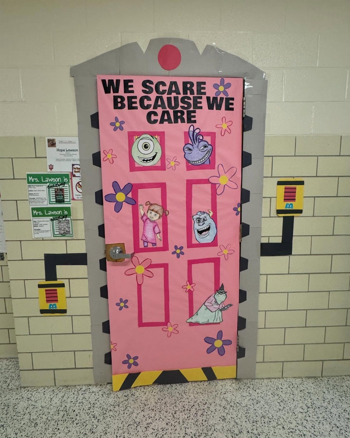 Pink decorated classroom door with cartoon monsters and the text We Scare Because We Care