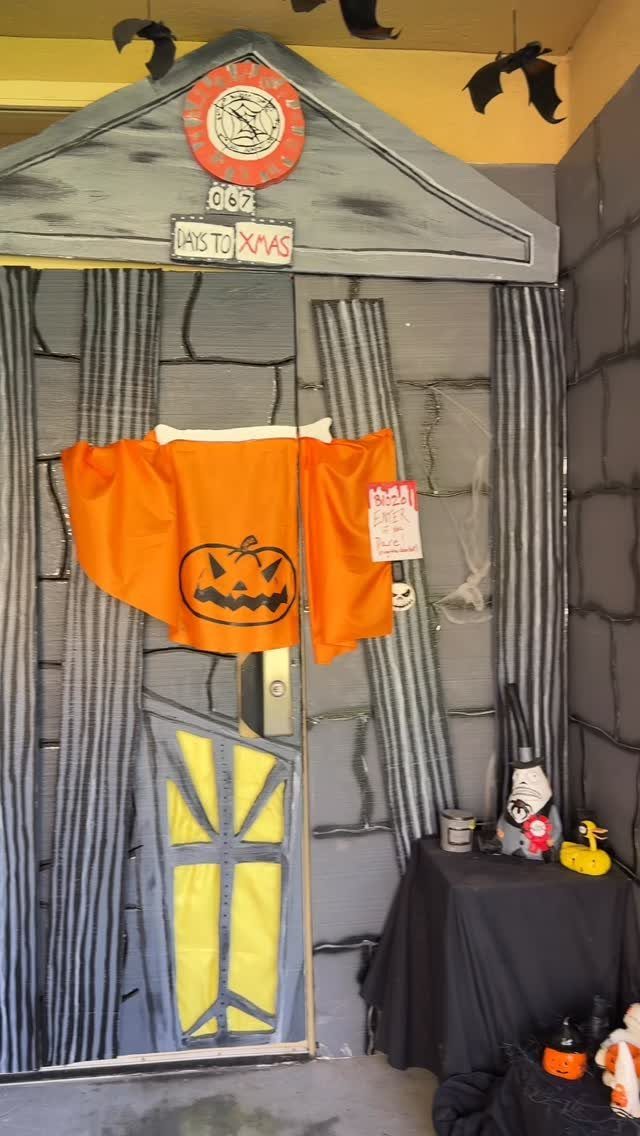 Classroom door decorated as a stone house with pumpkin cloth and Christmas countdown.
