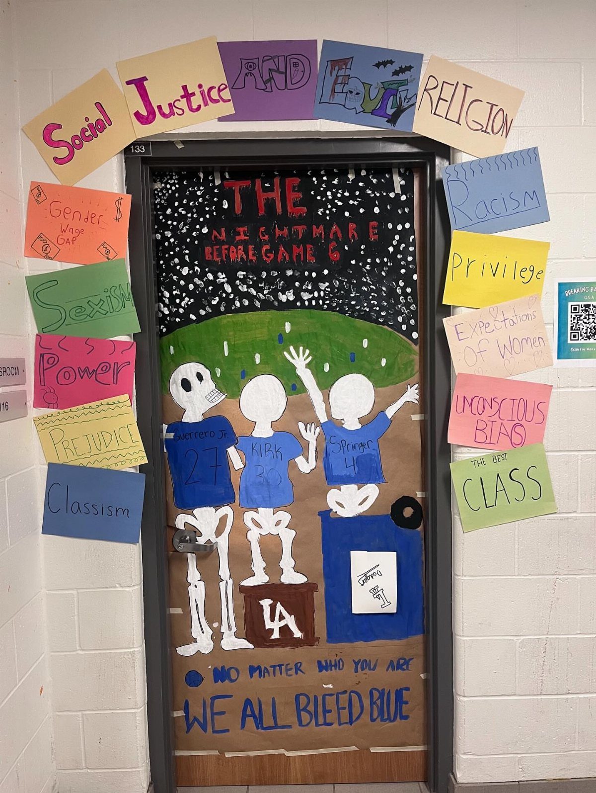 Classroom door decorated with skeletons and social justice signs for Halloween.