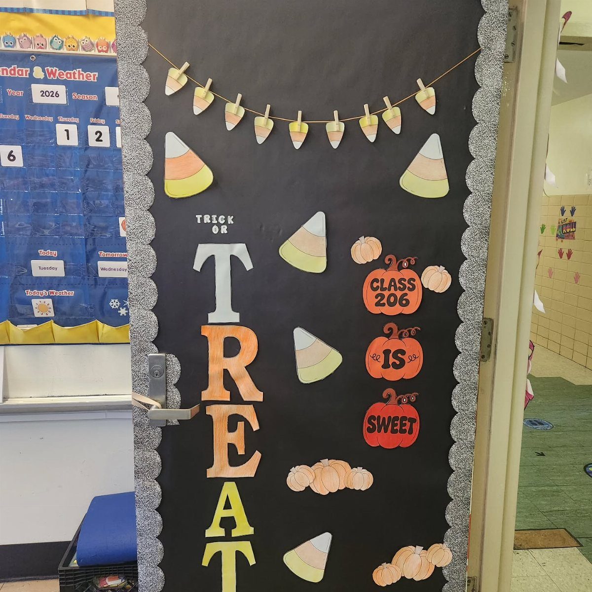 Decorated black classroom door with candy corn, pumpkins, and Trick or Treat sign.