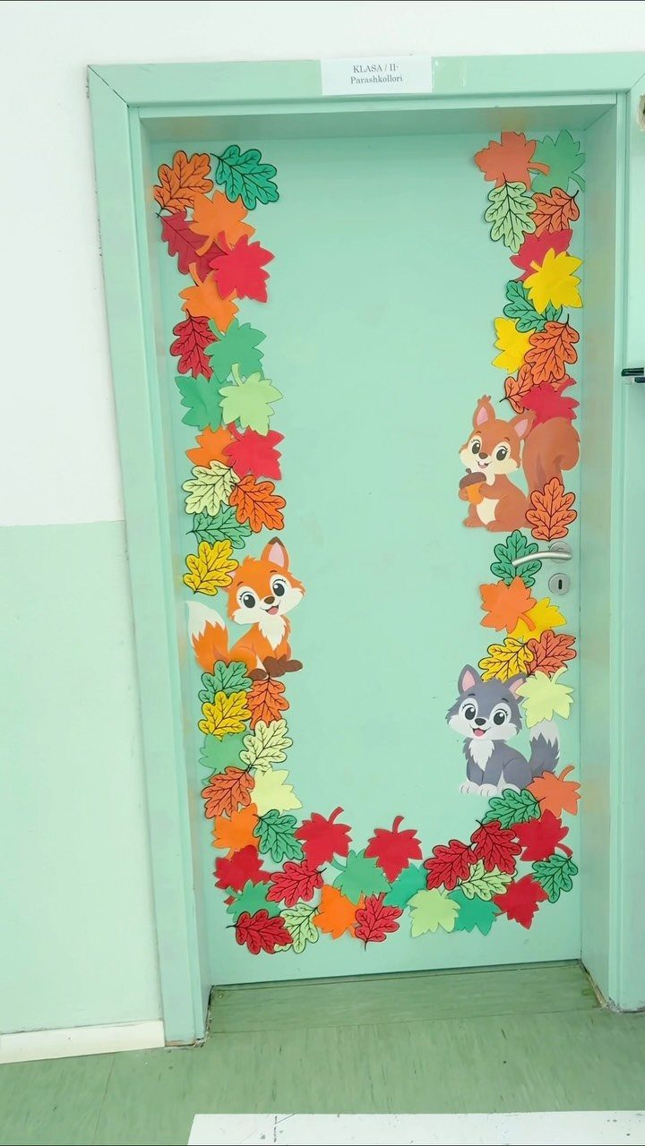 Classroom door decorated with colorful autumn leaves and cartoon forest animals.