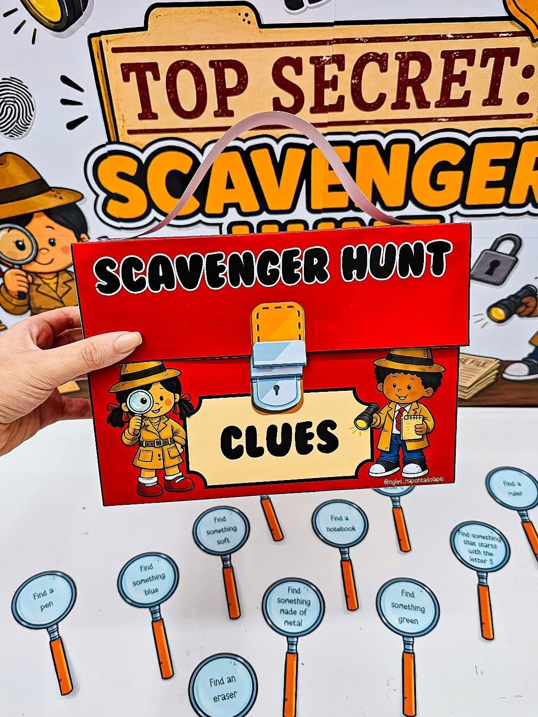Red scavenger hunt clue briefcase and magnifying glass clue cards on white surface