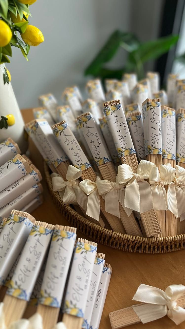 Wooden utensils wrapped in lemon-themed paper and cream ribbons in a wicker basket.