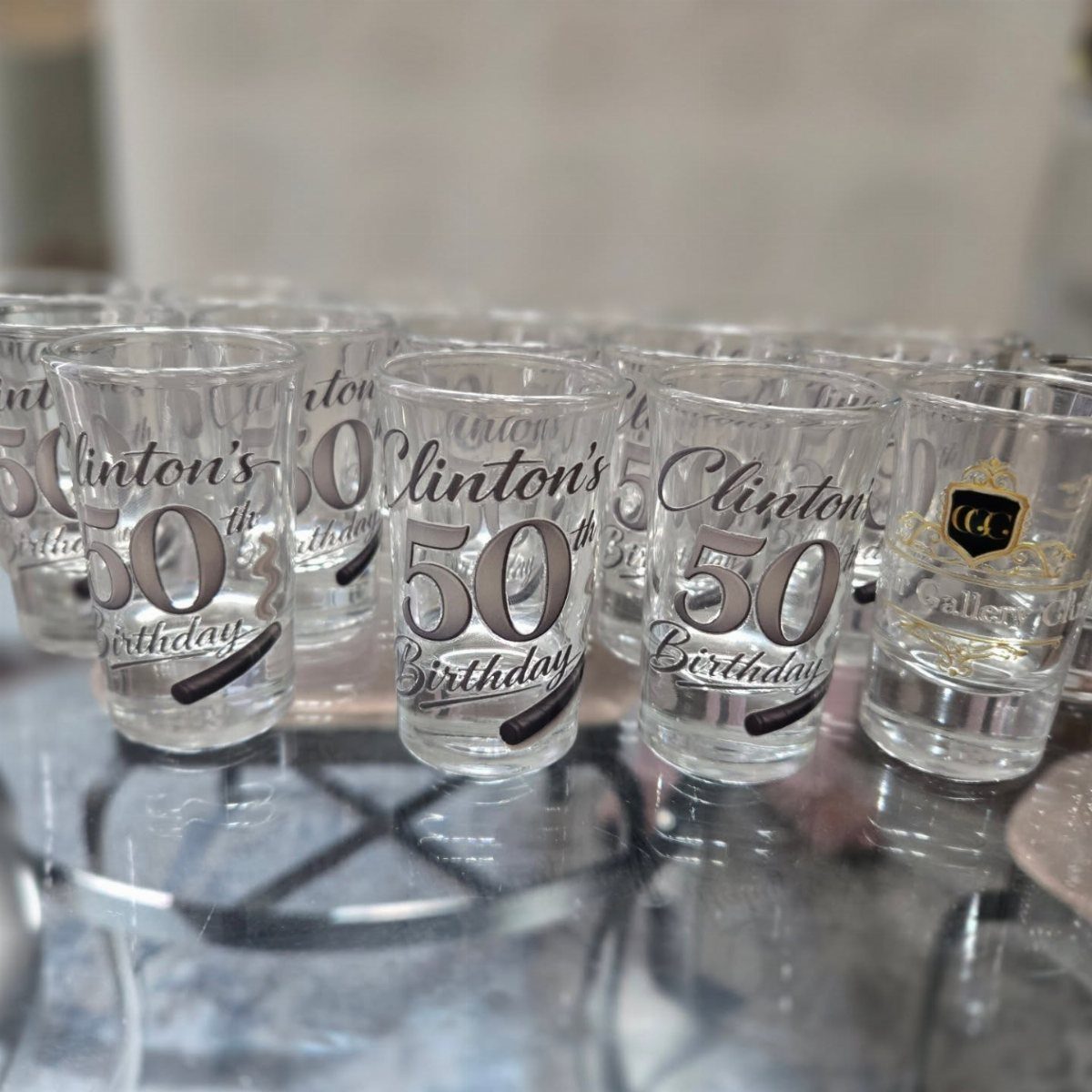 Personalized shot glasses with Clinton's 50th Birthday printed in black on clear glass.