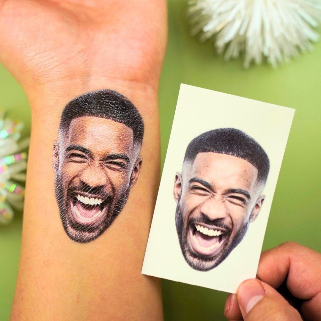 Temporary tattoo of a smiling man's face on a wrist next to its design.
