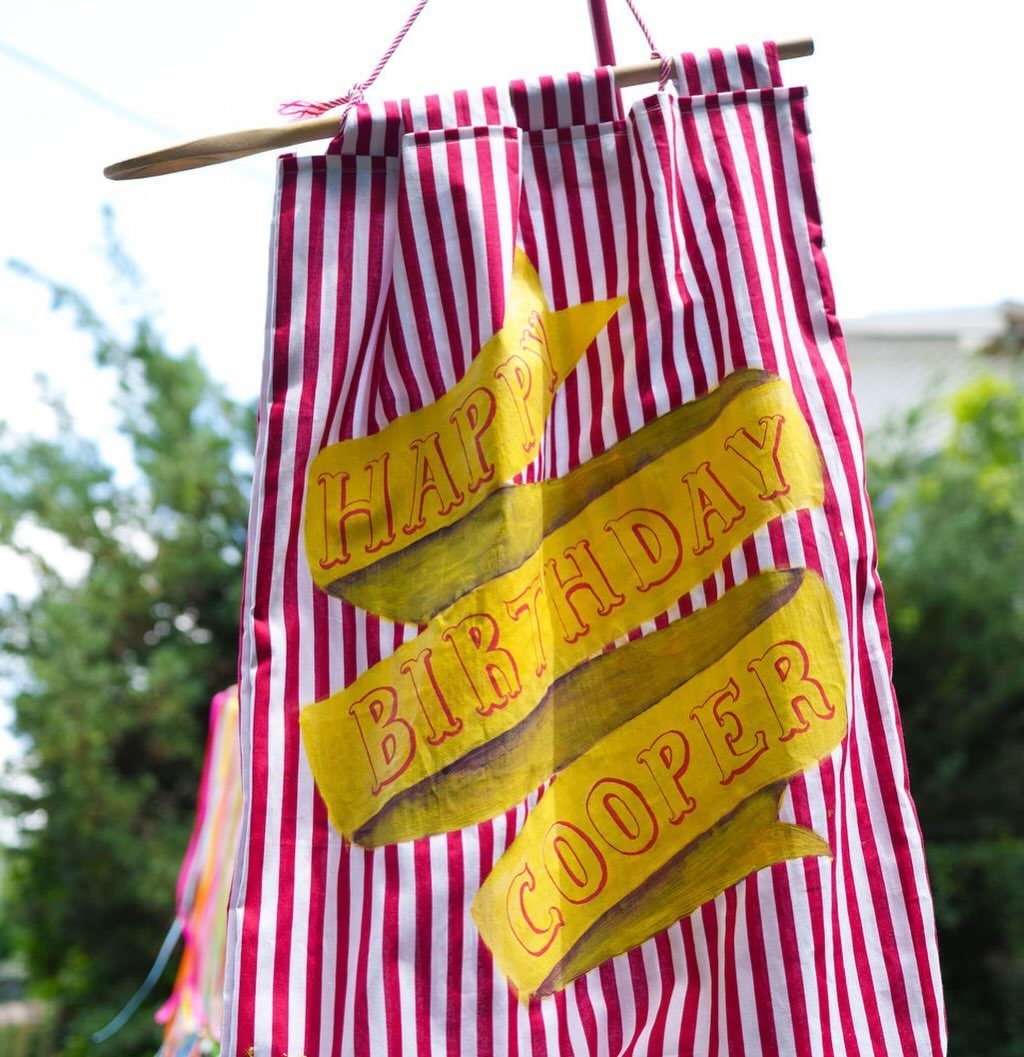 Handmade red and white striped birthday banner with yellow ribbons for Cooper.