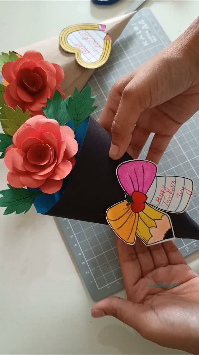 Handmade paper rose bouquet with a cartoon teacher illustration for Teacher's Day.