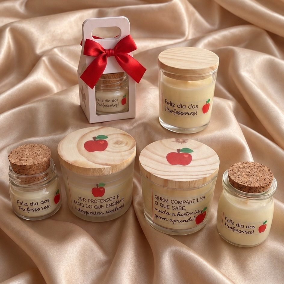 Six scented candles in glass jars with apple labels on gold satin fabric.