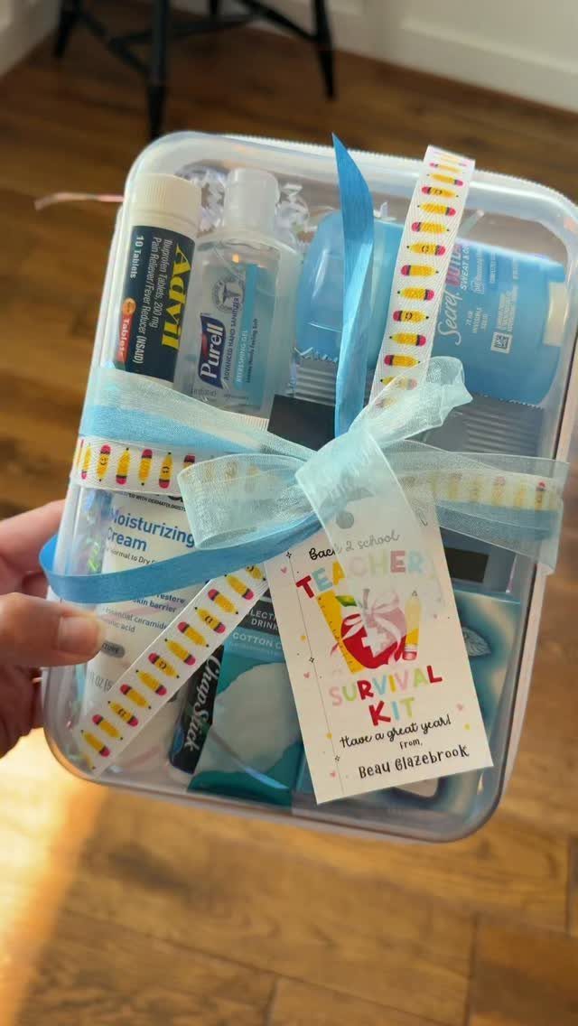 Teacher survival kit in a clear plastic bin with a blue ribbon bow.