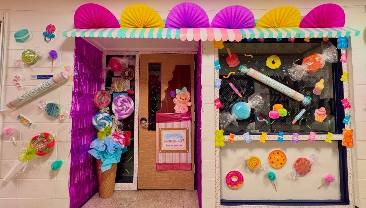 Classroom doorway decorated as a candy shop with oversized colorful candy props and awning.