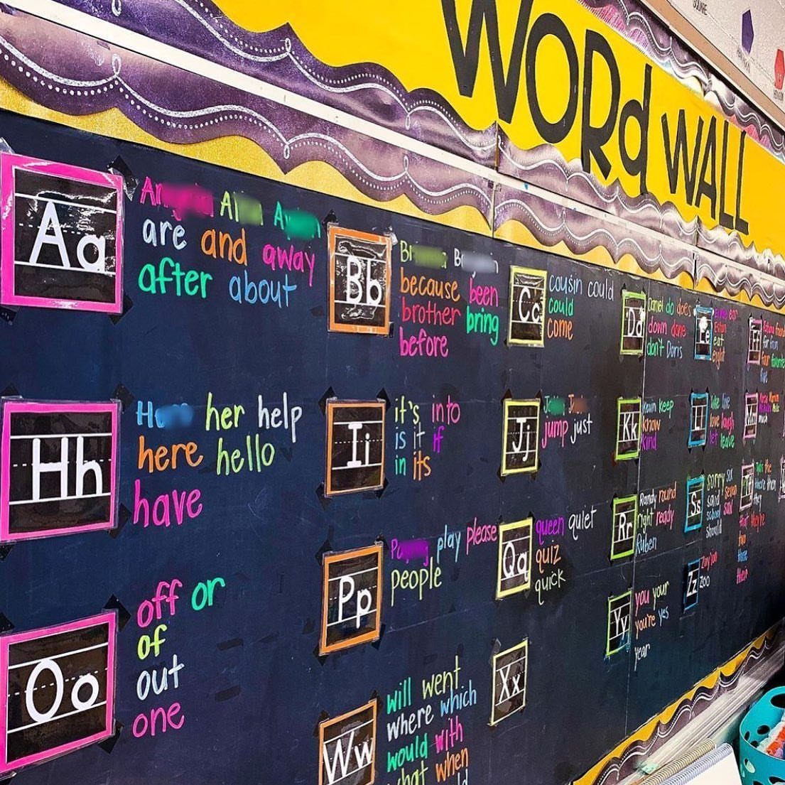 Classroom word wall with neon letters and words on a dark chalkboard background.