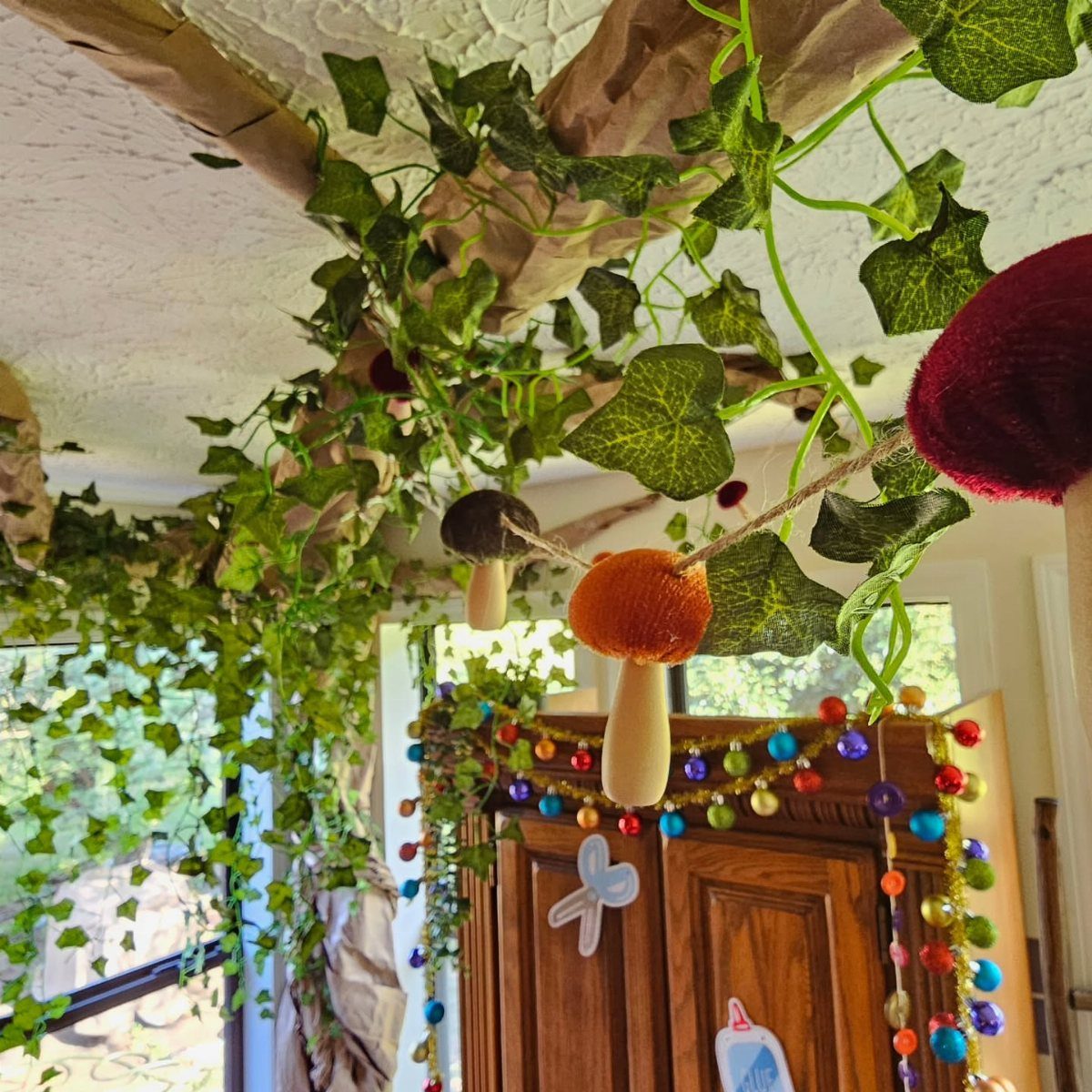 Artificial ivy and mushrooms decorating a ceiling for a nature classroom theme