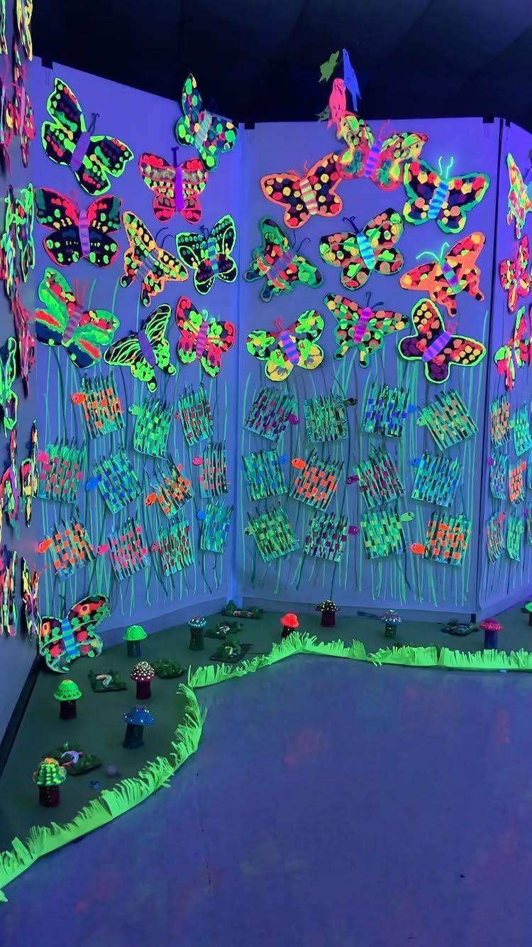 Neon glow-in-the-dark butterflies decorating the walls and floor of a themed room.