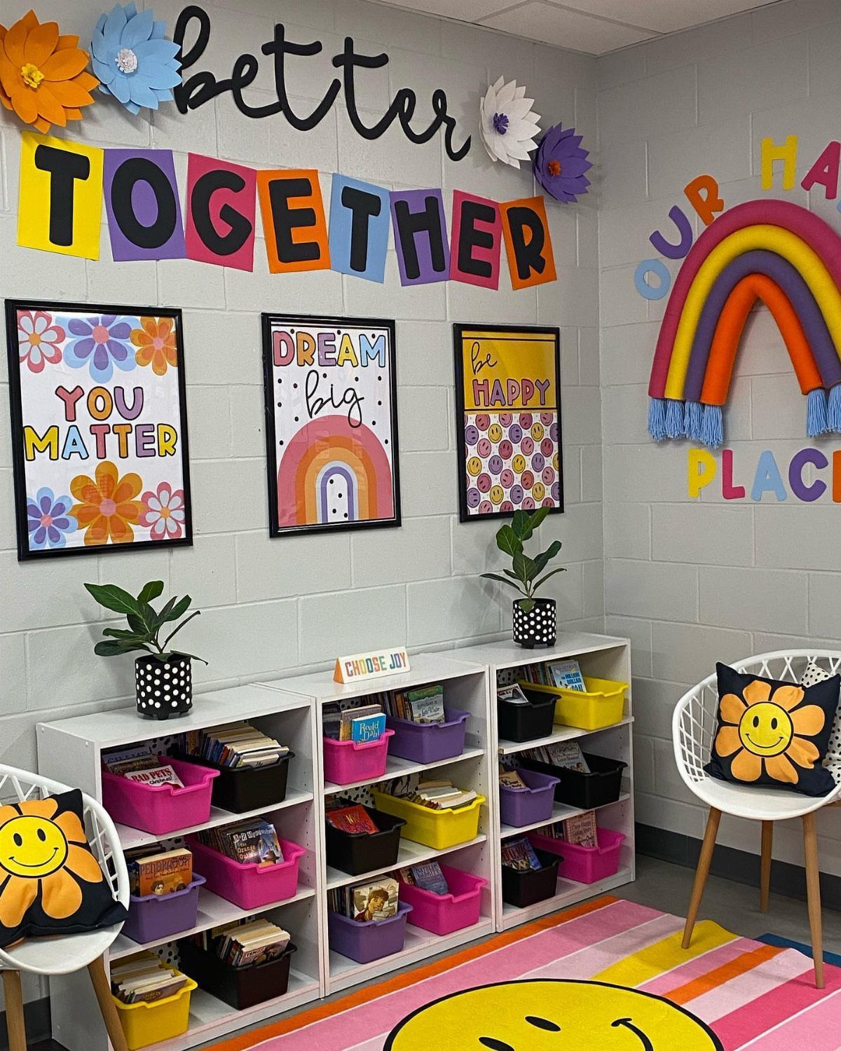 Colorful classroom corner with retro floral posters, rainbow wall art, and smiley face rug.