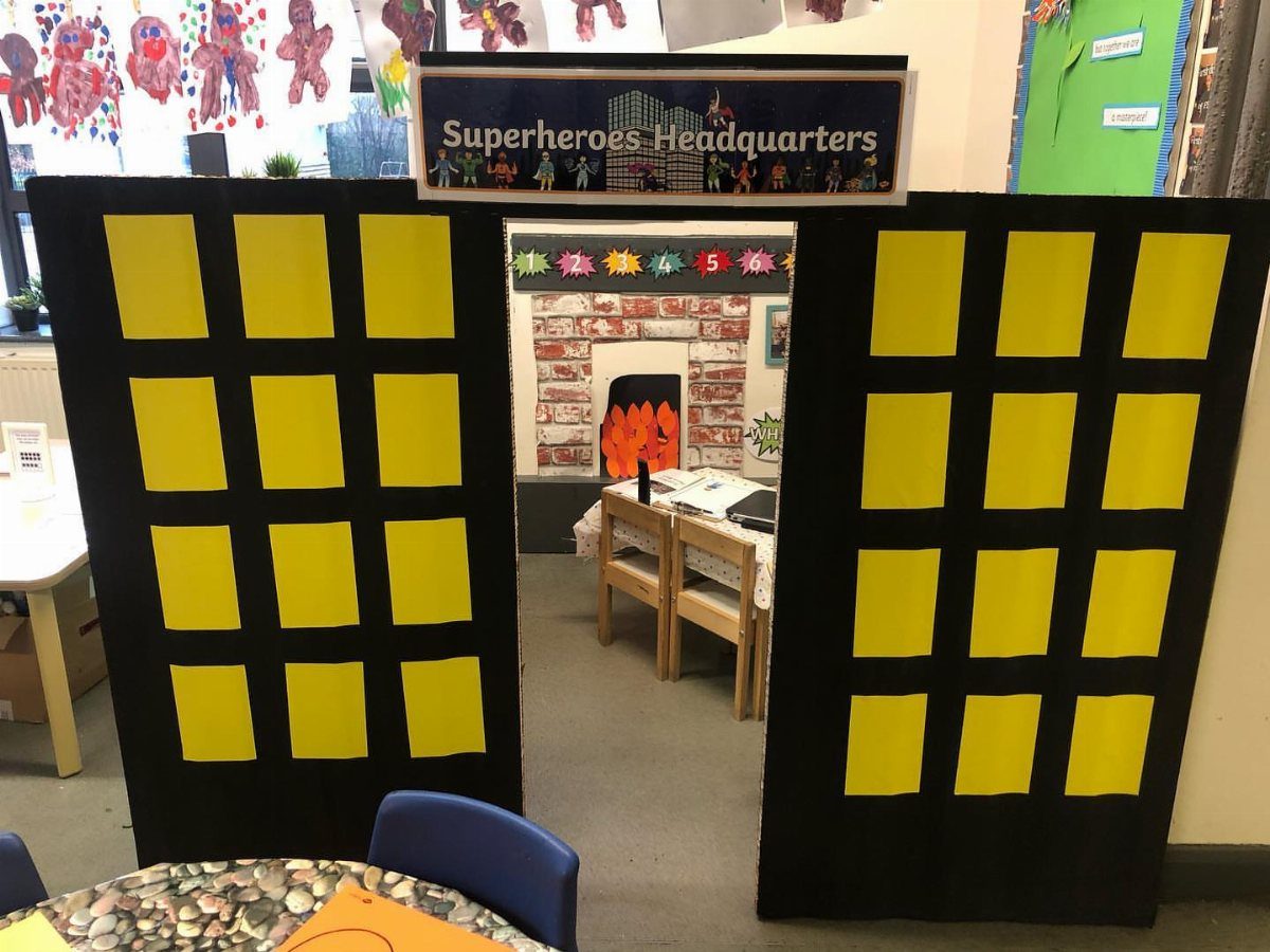 Superheroes Headquarters classroom entrance with black and yellow grid panels and star decorations.