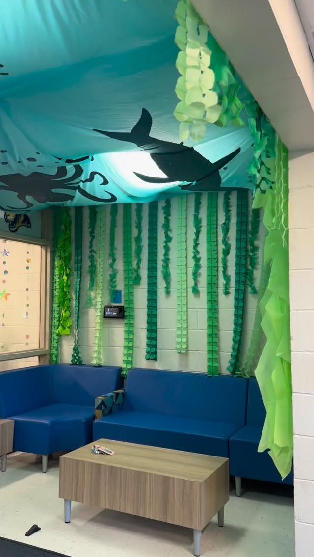 Under the sea classroom theme with blue sofas and green seaweed streamers.