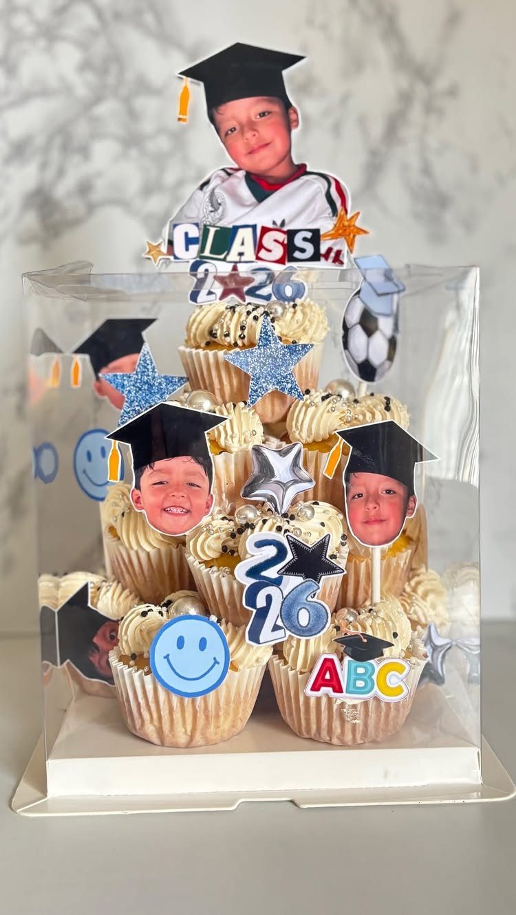 Cupcake graduation tower with photo toppers, blue stars, and Class of 2026 signs.