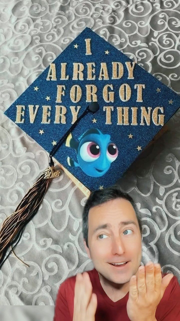 Blue glittery graduation cap with funny quote and Dory character held by man.