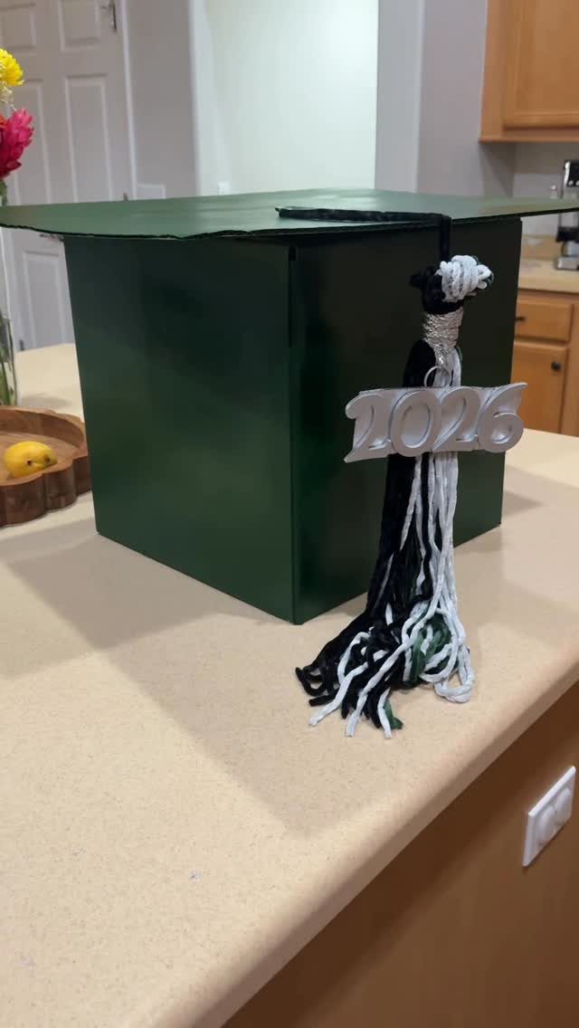 Graduation cap with a black and white tassel featuring a silver 2026 charm.