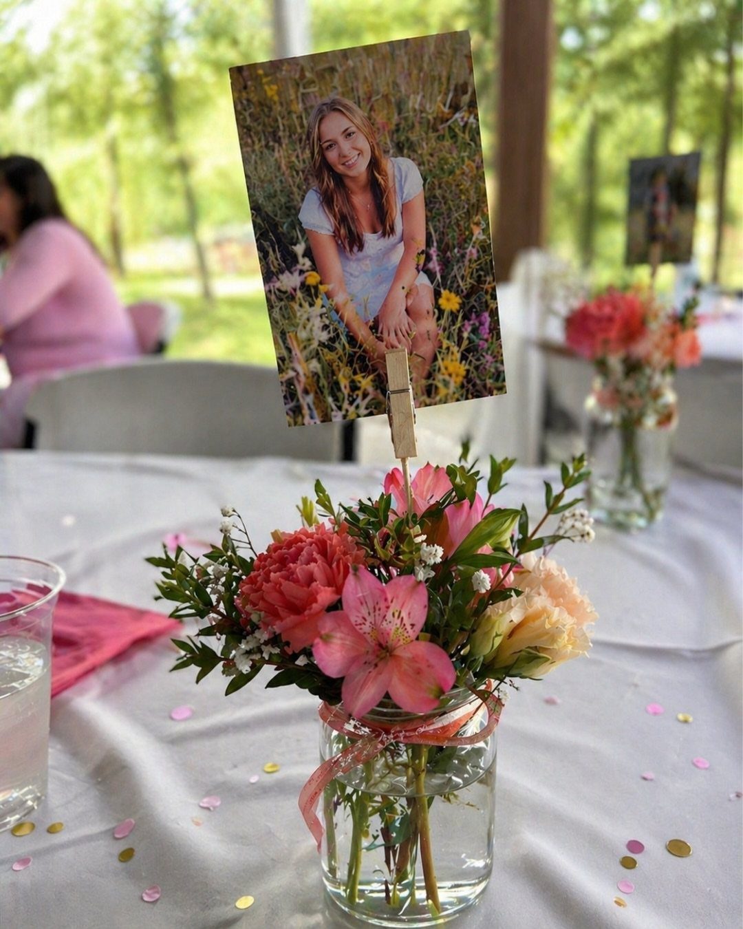 Floral arrangement in a glass jar with a clipped photo as a centerpiece.