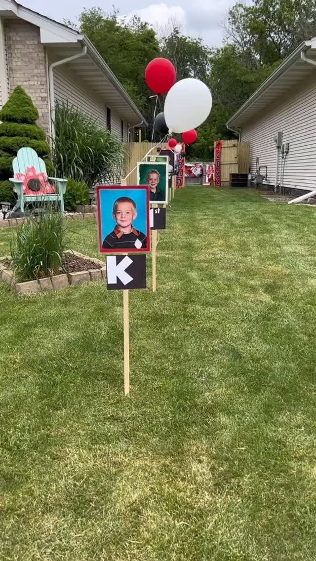 Backyard party decorations featuring photos of a boy and red and white balloons.