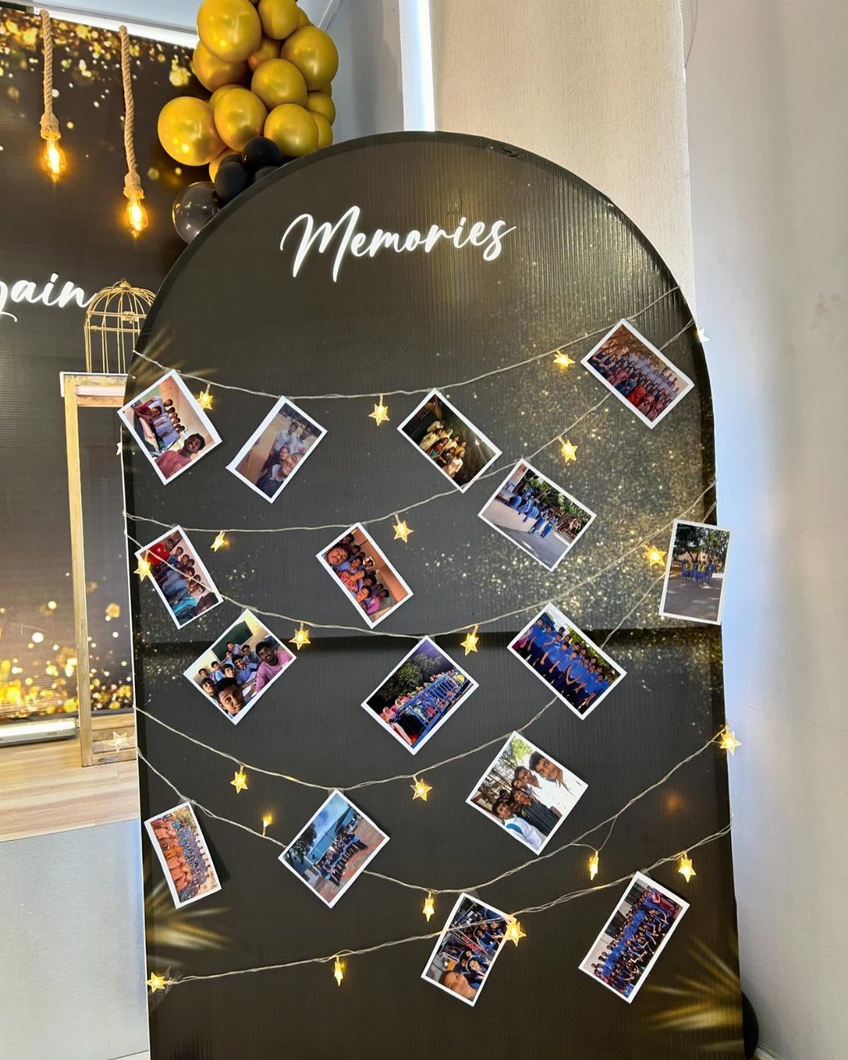 Black arched backdrop with photos clipped to fairy lights and 'Memories' text.