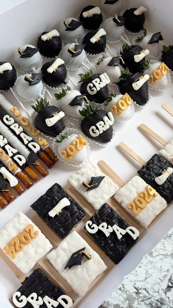 Graduation themed desserts including chocolate covered strawberries and rice cereal treats in a box