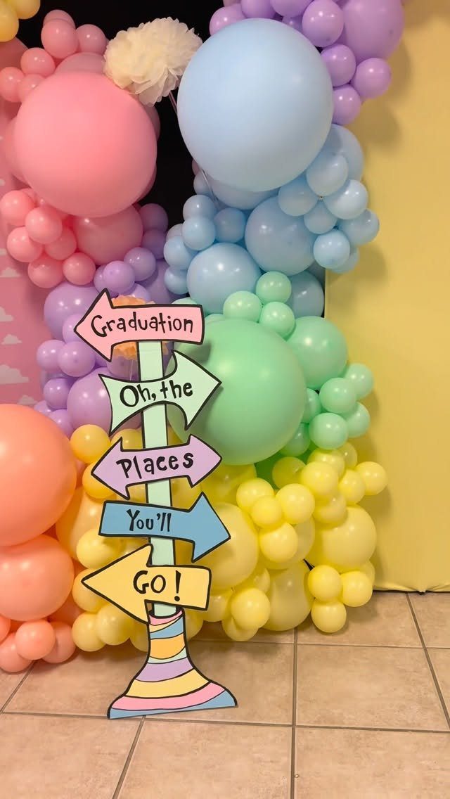 Colorful pastel balloon arch with a signpost reading Oh the Places You'll Go