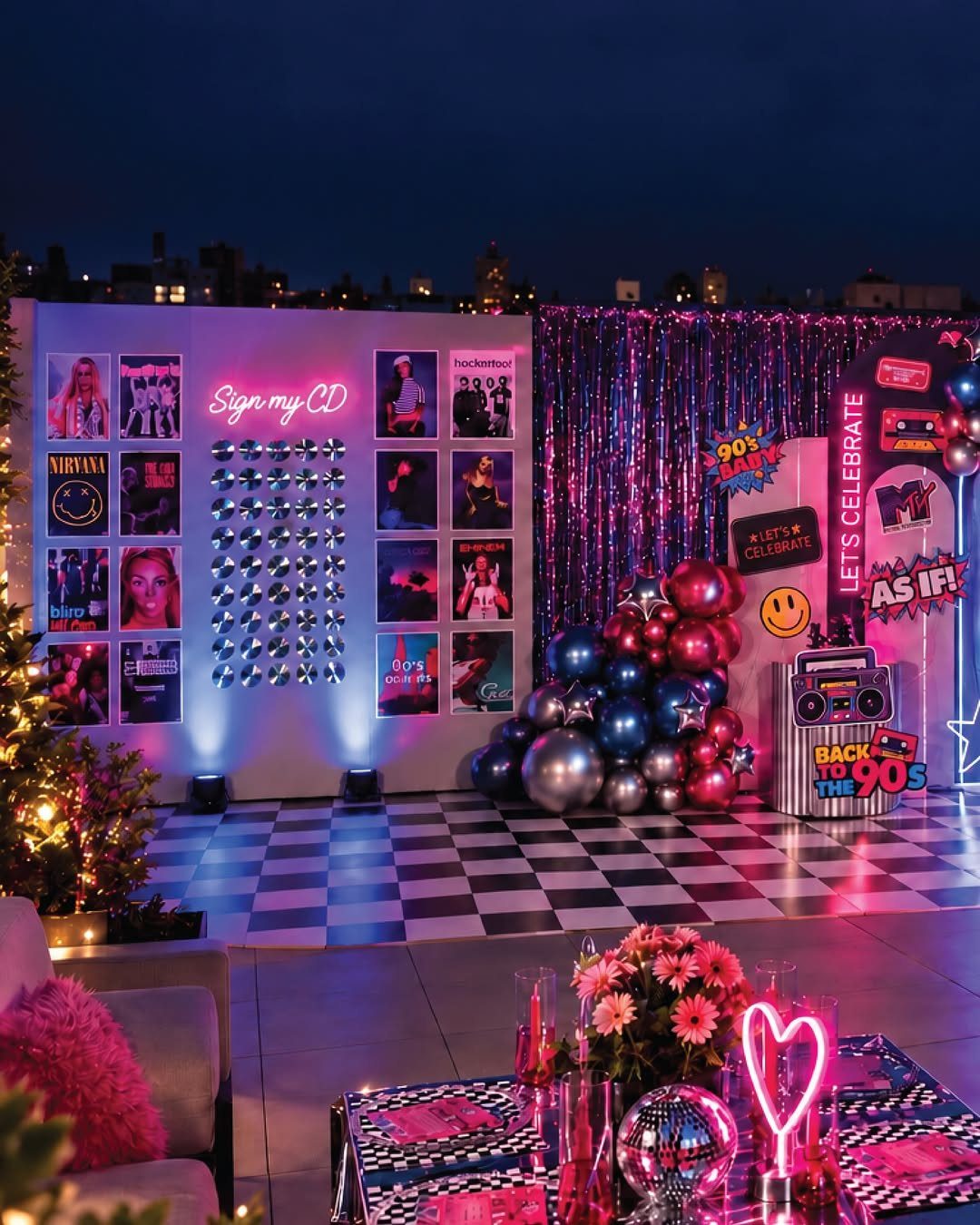 90s themed party setup with checkered floor, neon lights, and CD wall.
