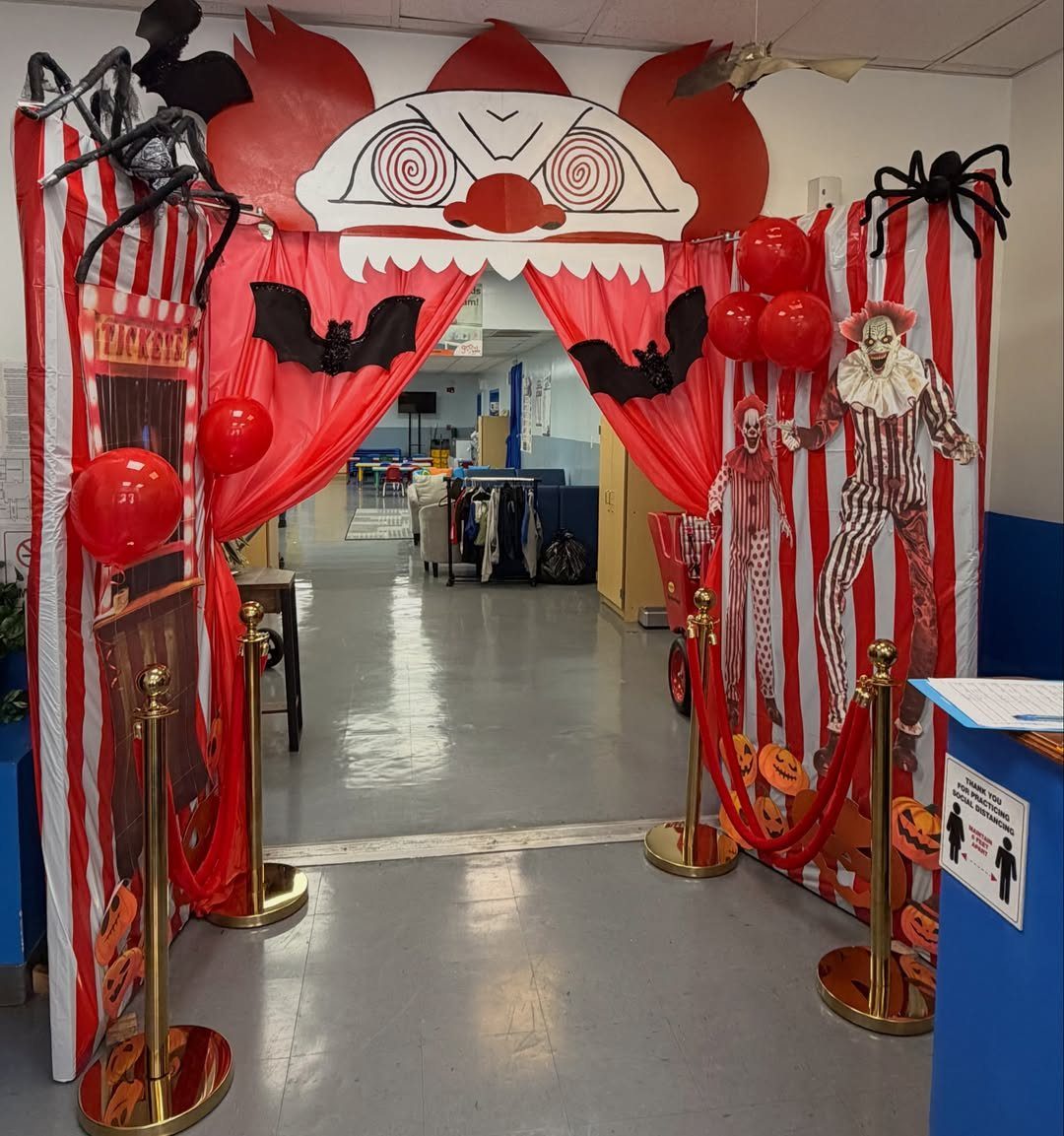 Creepy circus themed classroom doorway with red striped curtains and clown decorations