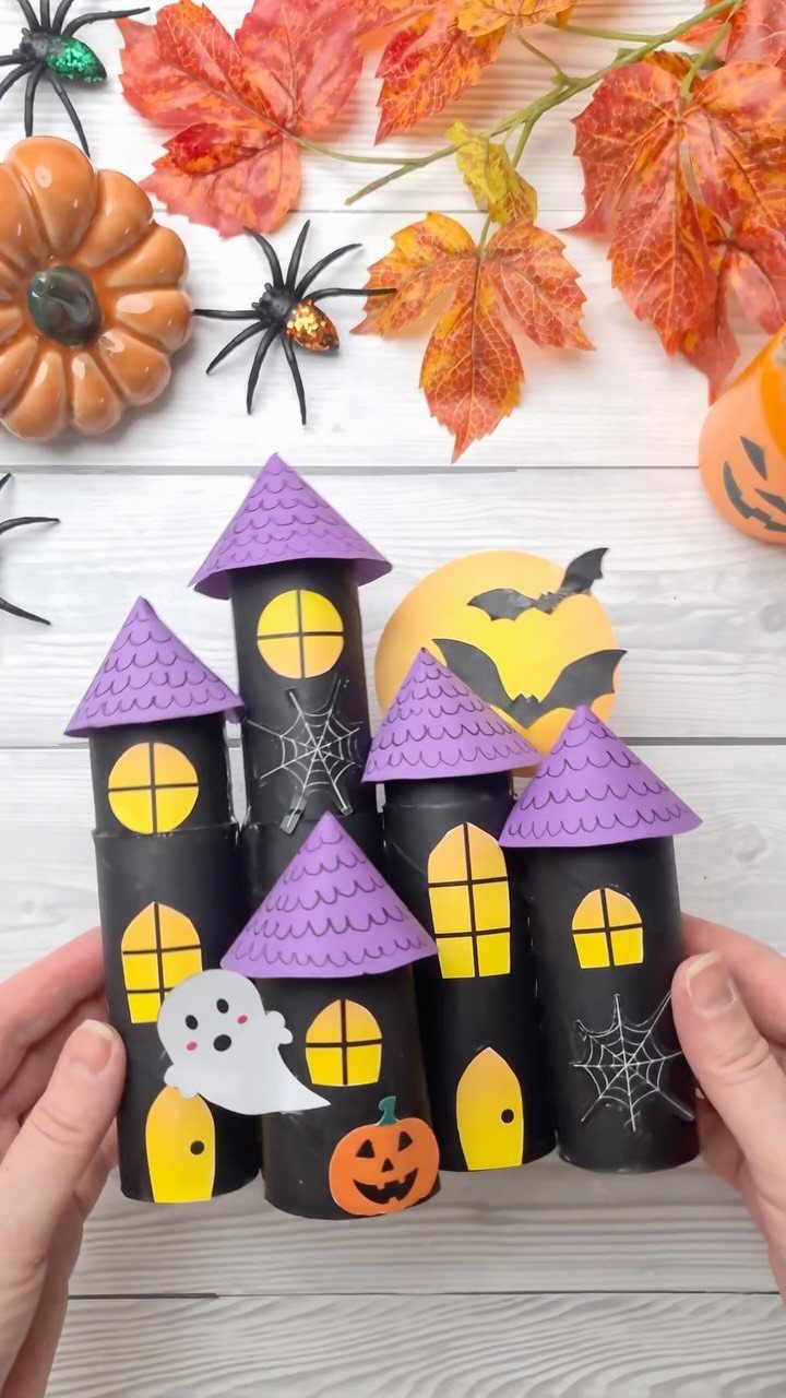 Handmade Halloween castle craft made from black cardboard tubes and purple paper roofs.