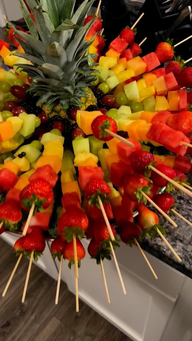 Fruit kabobs with strawberries and melon arranged around a central pineapple centerpiece.