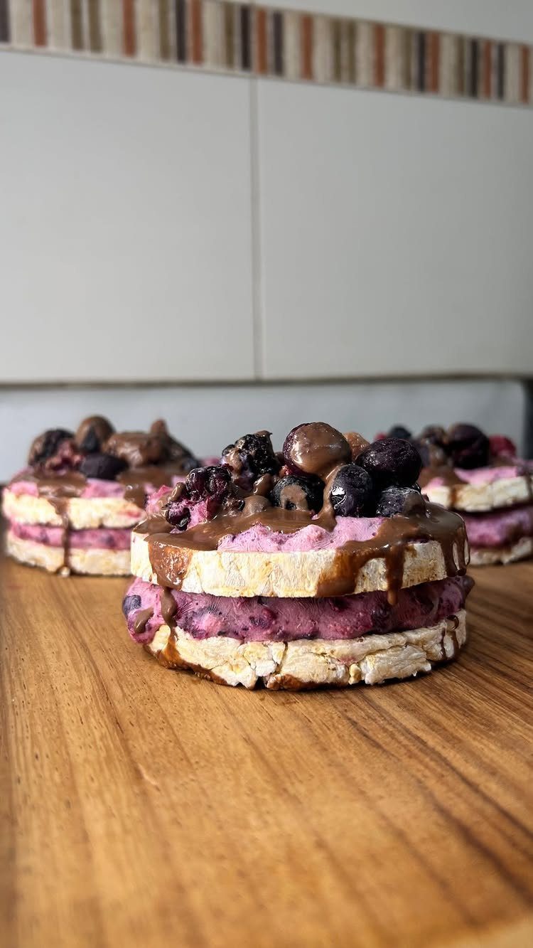 Rice cake sandwiches filled with berry cream and topped with blueberries and caramel.