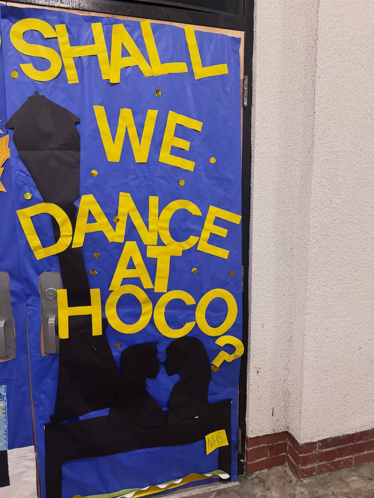 Blue decorated door with yellow text asking Shall we dance at Hoco?