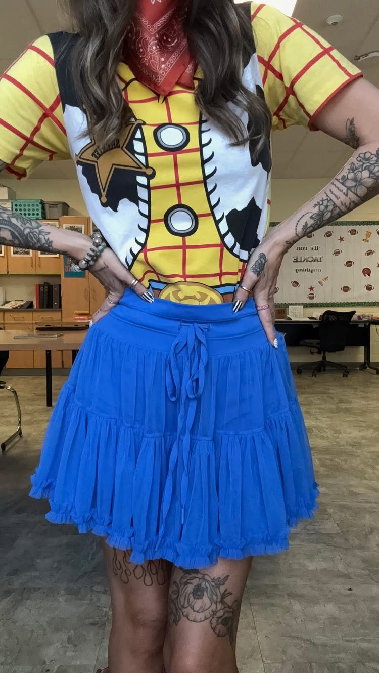Person dressed as Woody from Toy Story wearing a yellow shirt and blue skirt.